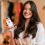 Filipino woman in her 20s holding a phone showing a shopping app
